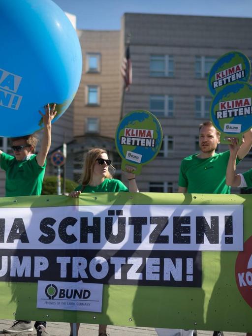 Aktivisten der Umweltorganisation demonstrieren gegen die Klimapoltik der USA mit Transparenten