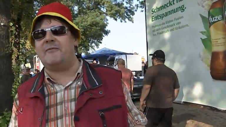 Ein Pegida-Demonstrant und LKA-Mitarbeiter in Sachsen fordert Journalisten auf mit zur Polizei zu kommen. Hinter ihm stehen Polizeifahrzeuge und mehrere Polizisten. Ein Pegida-Demonstrant und LKA-Mitarbeiter in Sachsen fordert Journalisten auf mit zur Polizei zu kommen. Hinter ihm stehen Polizeifahrzeuge und mehrere Polizisten.