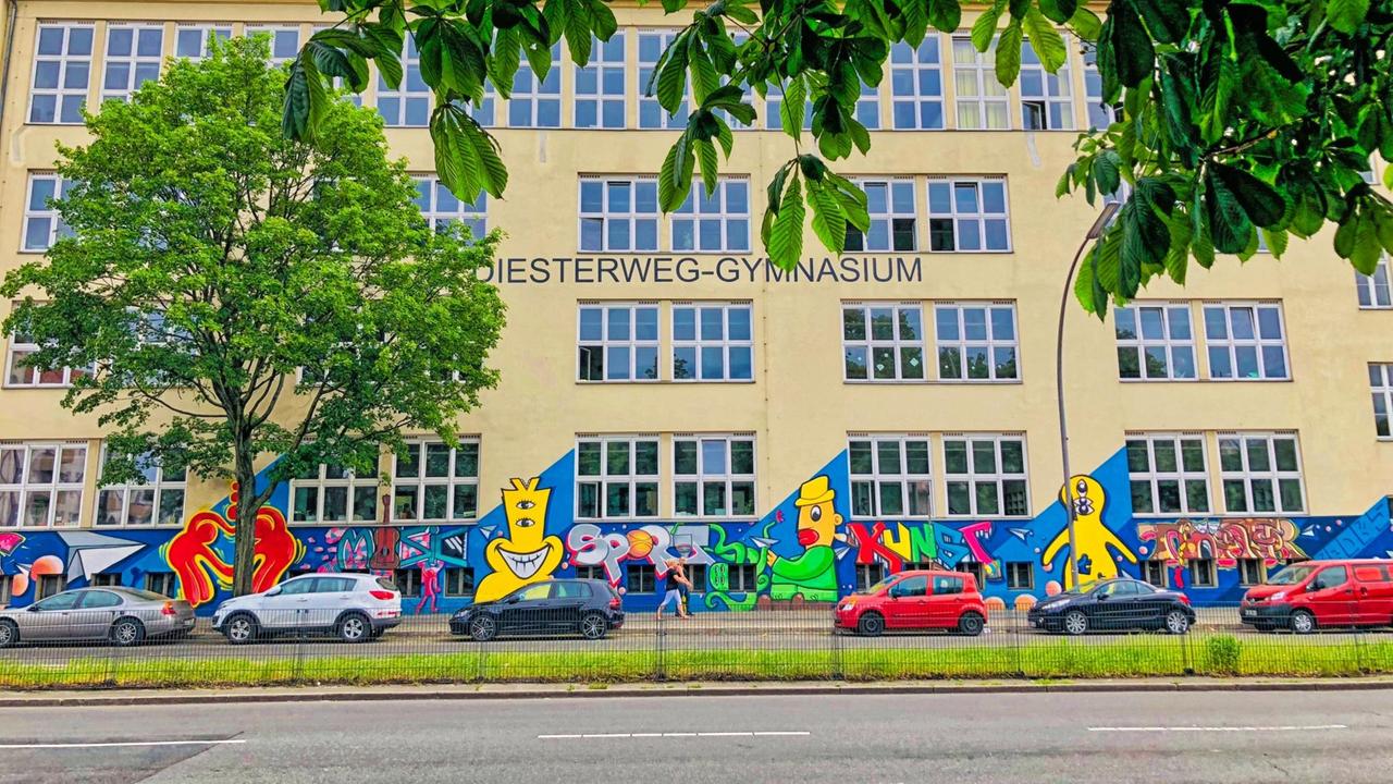 Die gelbe Fassade des Diesterweg-Gymnasium ist mit bunten Malereien verziert.