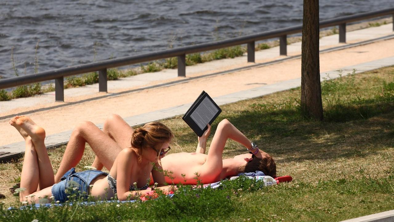 Leser mit E-Book-Reader im Park Leser mit E-Book-Reader im Park