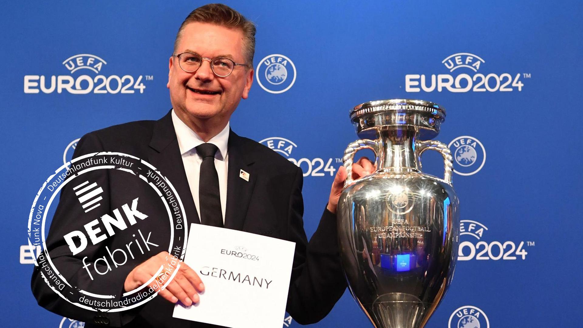 DFB-Präsident Reinhard Grindel von der deutschen Delegation hält einen Zettel mit "Germany" neben dem EM-Pokal während der Bekanntgabe-Zeremonie zur Ausrichtung der Fußball-Europameisterschaft 2024. DFB-Präsident Reinhard Grindel von der deutschen Delegation hält einen Zettel mit "Germany" neben dem EM-Pokal während der Bekanntgabe-Zeremonie zur Ausrichtung der Fußball-Europameisterschaft 2024.