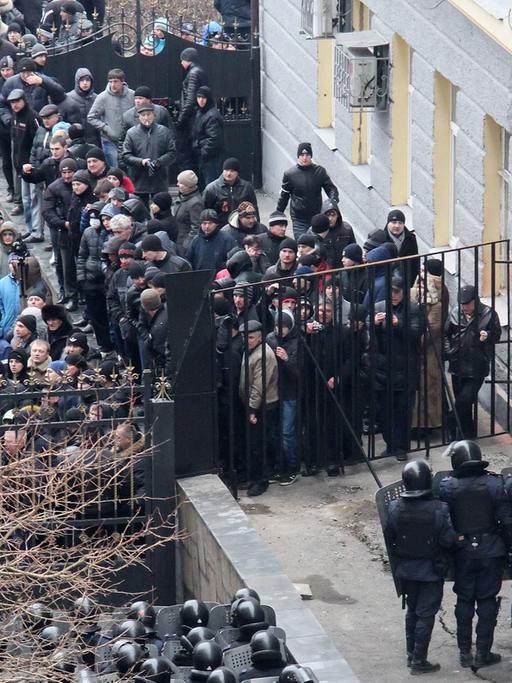 Prorussische Demonstranten, die ein Gebäude der Regionalverwaltung im ukrainischen Donezk erstürmt haben, stehen Polizisten gegenüber.