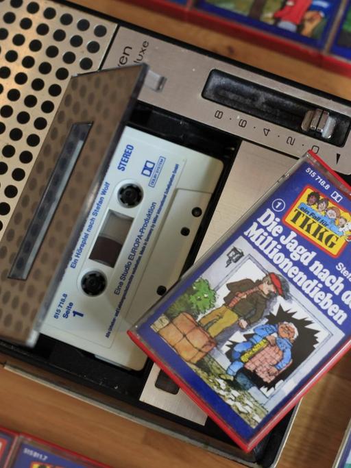 Eine Audiokassette der Jugend-Hörspielreihe "TKKG" mit dem Titel "Die Jagd nach den Millionendieben" liegt in einem Kassettenrekorder, die Hülle der Kassette liegt auf dem Rekorder. Am 31.03.2021 hat «TKKG» runden Geburtstag. Rund 40 Millionen Tonträger wurden bisher verkauft. Heute ist «TKKG» ein Stück Popkultur.