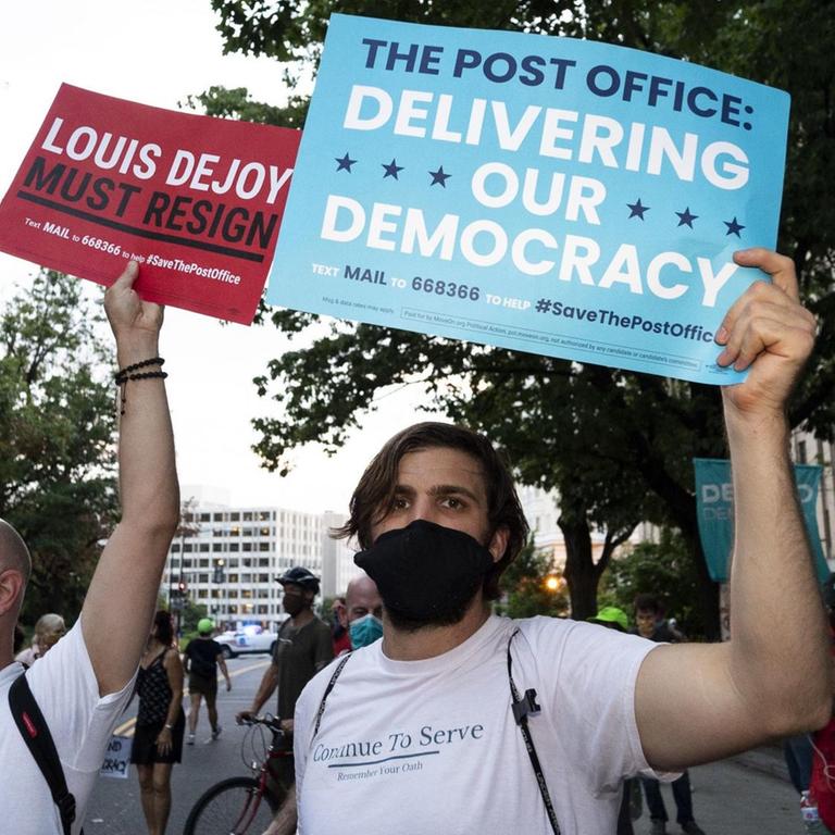August 23, 2020, Washington, DC, United States: August 23, 2020 - Washington, DC, United States: Protester holding signs saying Louis DeJoy must resign'' and The Post Office: Delivering Our Democracy'' in front of the DC home of USPS Postmaster General Louis DeJoy. (Credit Image: © Michael Brochstein/ZUMA Wire |