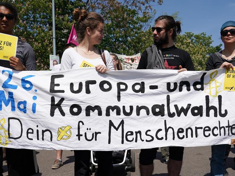 19.05.2019, Sachsen, Leipzig: Teilnehmer halten ein Transparent mit der Aufschrift "Europa- und Kommunalwahl - Dein Kreuz für Menschenrechte" bei der Demonstration für Europa.