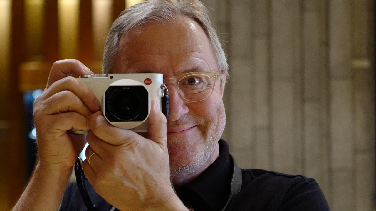 Der Schweizer Autor und Werbefachmann Frank Baumann posiert mit einer Kamera, die er sich vor das rechte Auge hält. Der Schweizer Autor und Werbefachmann Frank Baumann posiert mit einer Kamera, die er sich vor das rechte Auge hält.