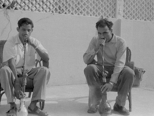 Zwei Männer im Pakistan der 1960er-Jahre rauchen Wasserpfeife.
