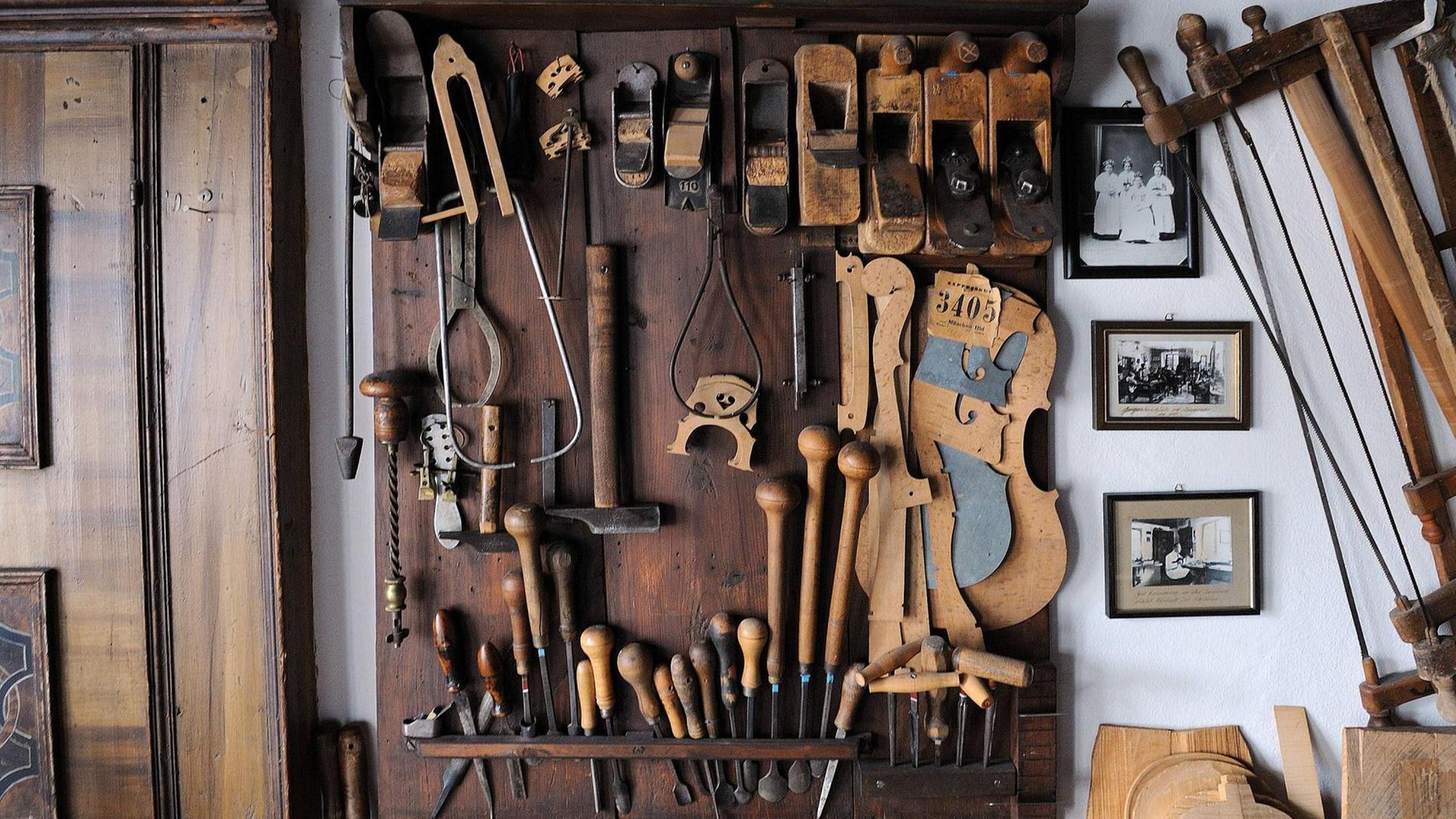 Blick auf viel verschiedenes Spezialwerkzeug, das an einer Wand in einer Geigenbau-Werkstatt hängt. Blick auf viel verschiedenes Spezialwerkzeug, das an einer Wand in einer Geigenbau-Werkstatt hängt.
