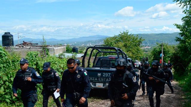 Mexikanische Polizisten sind auf dem Weg, dass in Iguala gefundene Massengrab zu untersuchen.