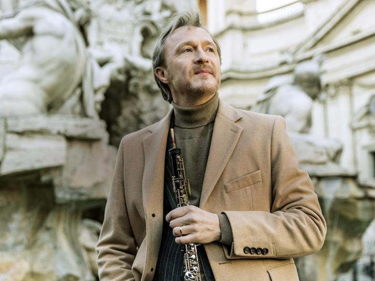 Porträt von Albrecht Mayer mit seiner Oboe in der Hand.