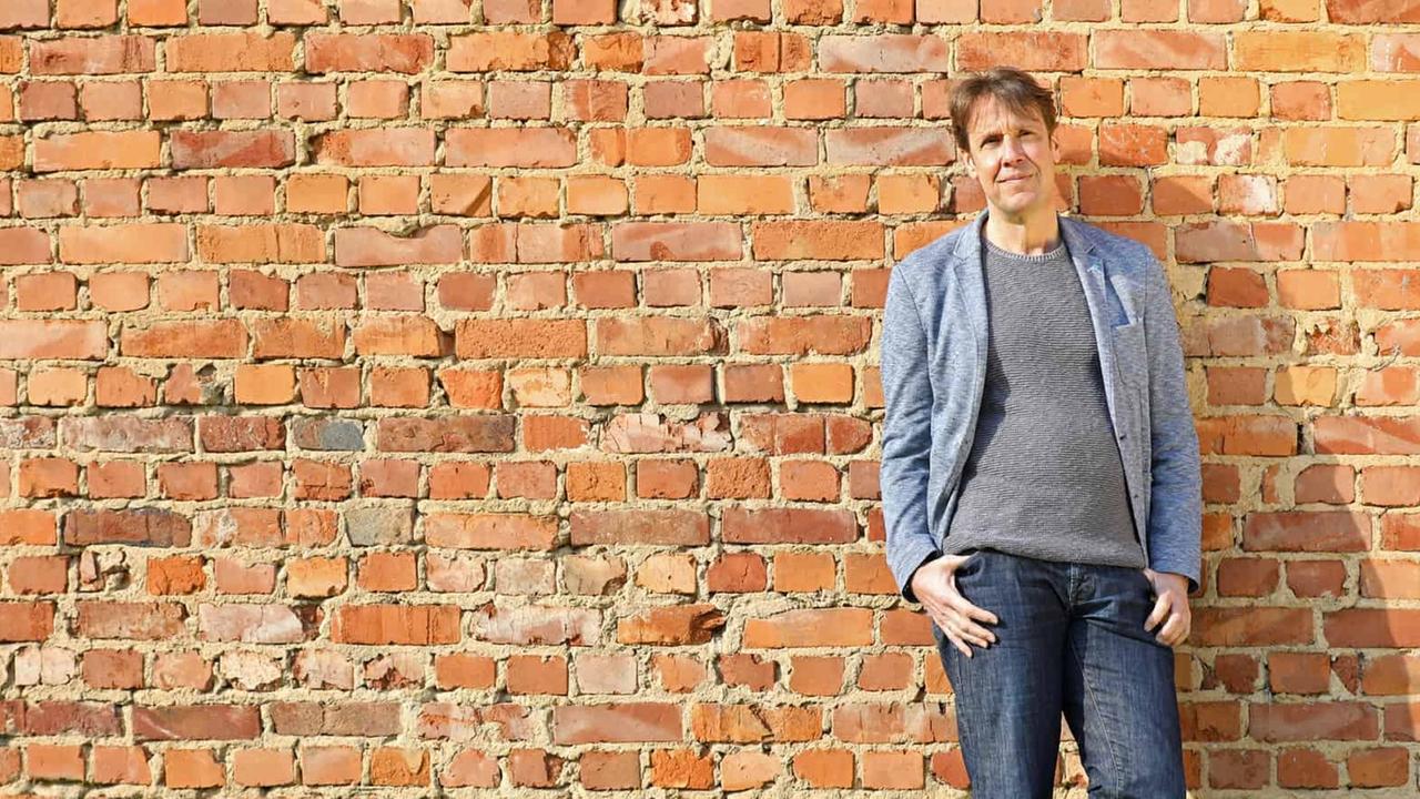 Der Philosoph Christoph Quarch an eine Backstein-Mauer gelehnt im Ganzkörperporträt. Der Philosoph Christoph Quarch an eine Backstein-Mauer gelehnt im Ganzkörperporträt.