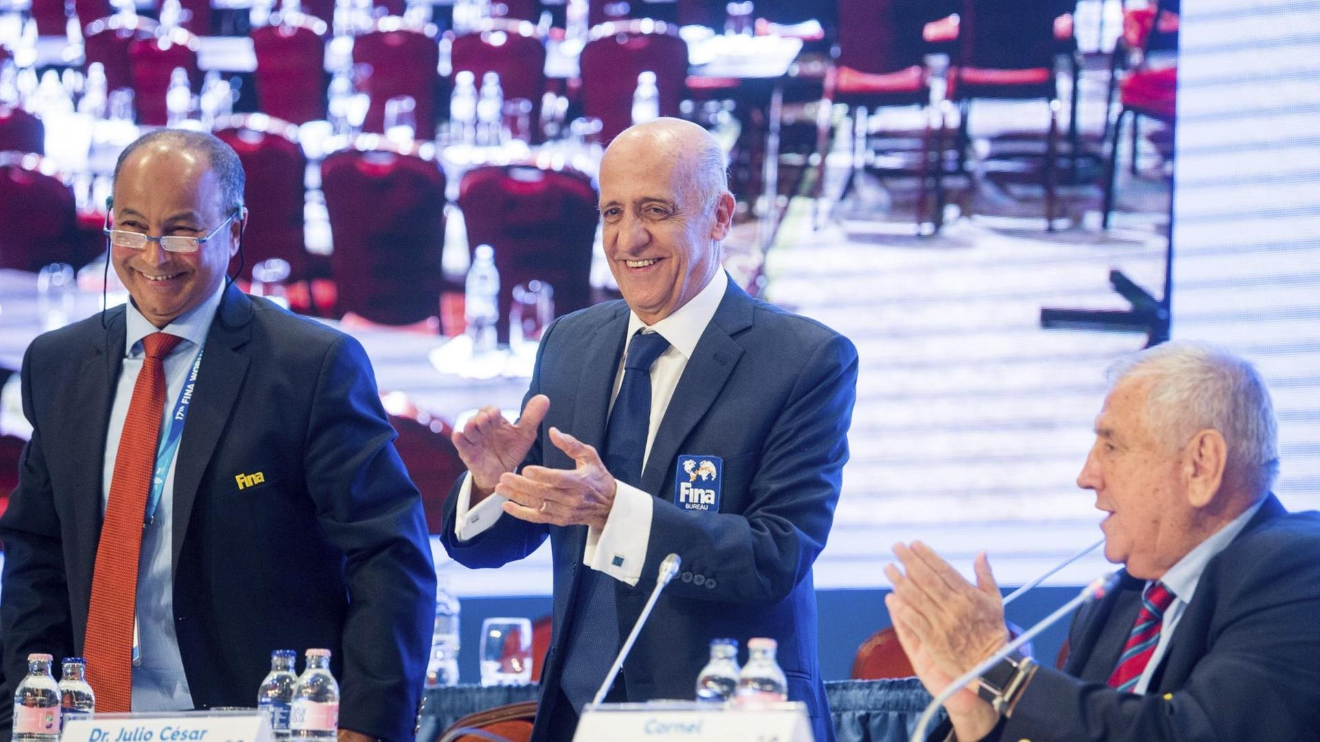 Neu gewählt und im Bild von links: FINA-Vize Husain Al-Musallam, daneben Präsident Julio Cesar Maglione und der geschäftsführende Direktor Cornel Marculescu in Budapest beim Kongress des Schwimm-Weltverbandes. Neu gewählt und im Bild von links: FINA-Vize Husain Al-Musallam, daneben Präsident Julio Cesar Maglione und der geschäftsführende Direktor Cornel Marculescu in Budapest beim Kongress des Schwimm-Weltverbandes.