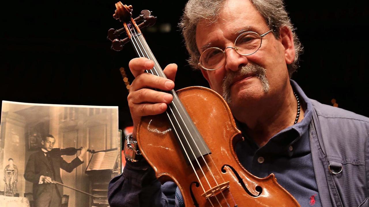 Geigenbauer Amnon Weinstein mit einer von ihm restaurierten Violine bei der Ausstellung "Violins of Hope" in Monaco. Geigenbauer Amnon Weinstein mit einer von ihm restaurierten Violine bei der Ausstellung "Violins of Hope" in Monaco.