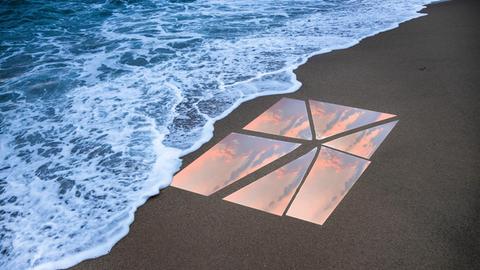 Ein zebrochener Spiegel liegt am Strand und spiegelt den Sonnenuntergang.