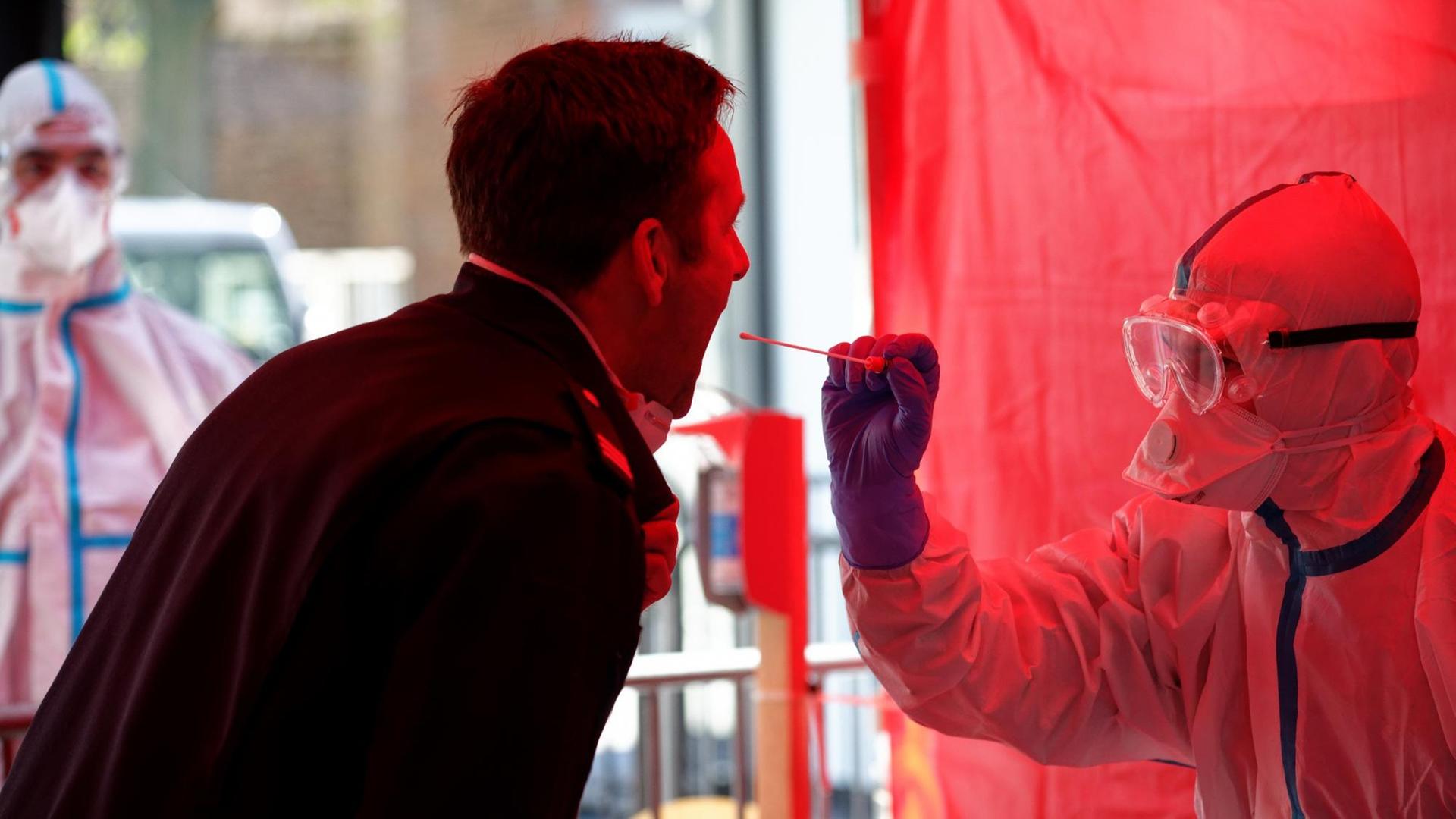 Einem Mitarbeiter der Berufsfeuerwehr Köln wird im dritten Infektionsschutzzentrum der Stadt Köln mit einem Stäbchen ein Abstrich für einen Test auf den Coronavirus entnommen. Einem Mitarbeiter der Berufsfeuerwehr Köln wird im dritten Infektionsschutzzentrum der Stadt Köln mit einem Stäbchen ein Abstrich für einen Test auf den Coronavirus entnommen.