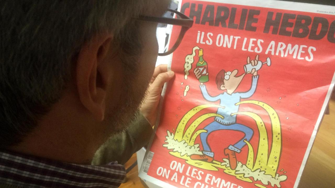 Ein Mann betrachtet am 18.11.2015 in Paris den aktuellen Titel der französischen Satirezeitung «Charlie Hebdo»
