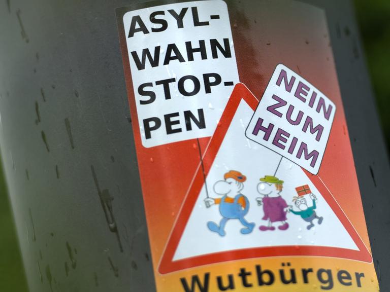 Ein Aufkleber "Asyl-Wahn Stoppen - Nein zum Heim - Wutbürger" klebt am 23.06.2015 an einem Laternenmast in unmittelbarer Nähe des Leonardo-Hotel in Freital (Sachsen).