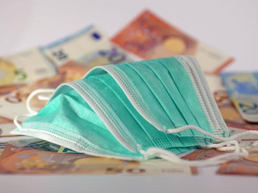 Mundschutz liegt auf Euro-Banknoten.