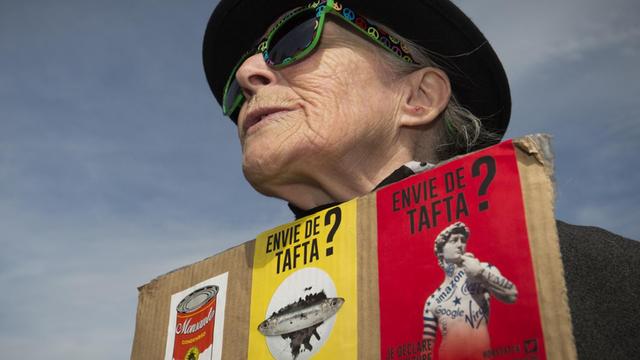 Eine Frau zeigt mit einem Plakat ihren Protest gegen TTIP (TAFTA) in Paris.