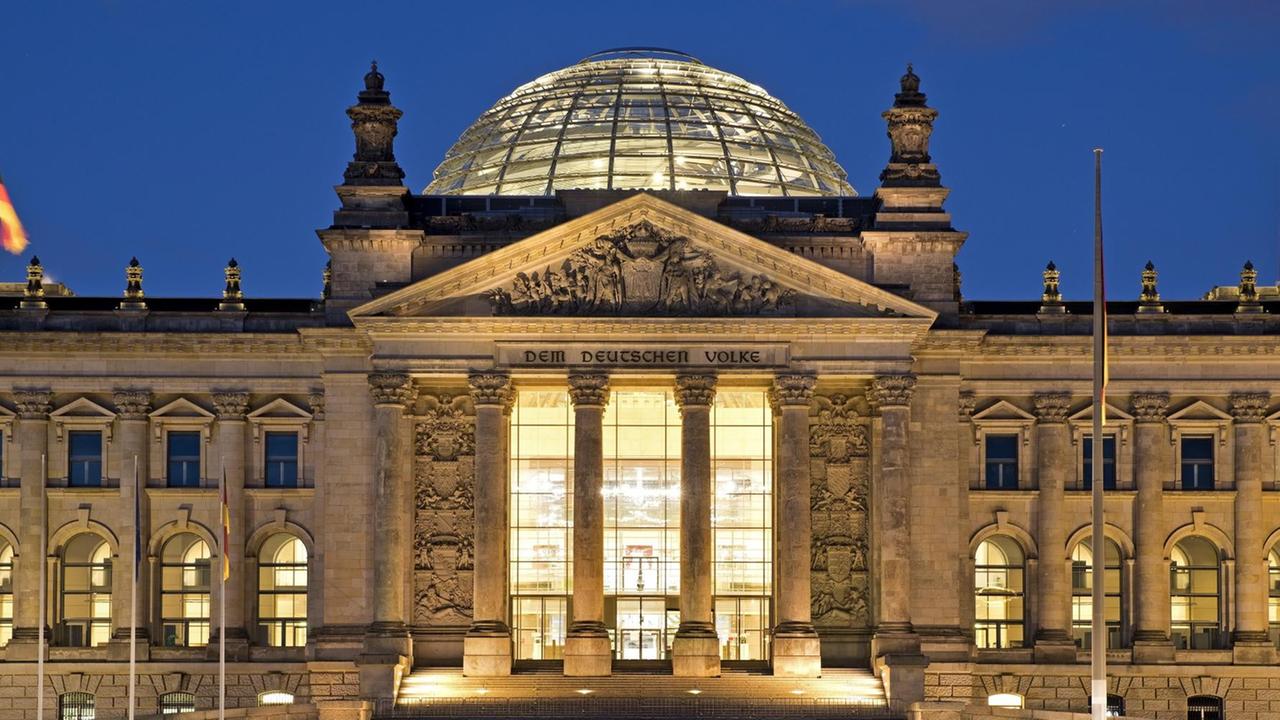 Der Reichstag am Abend. Blick auf den Vordereingang und die Aufschrift "Dem deutschen Volke".
