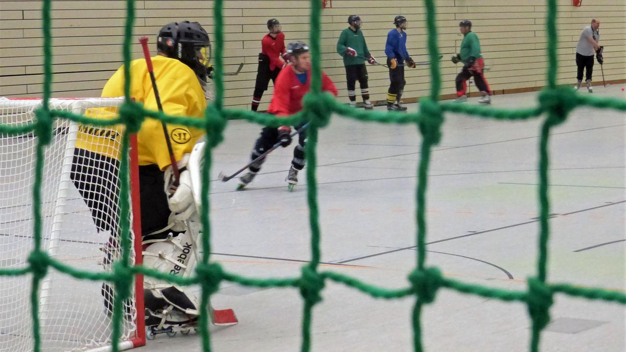 Inlinescater-Hockey-Spieler vom Tor aus fotografiert Inlinescater-Hockey-Spieler vom Tor aus fotografiert