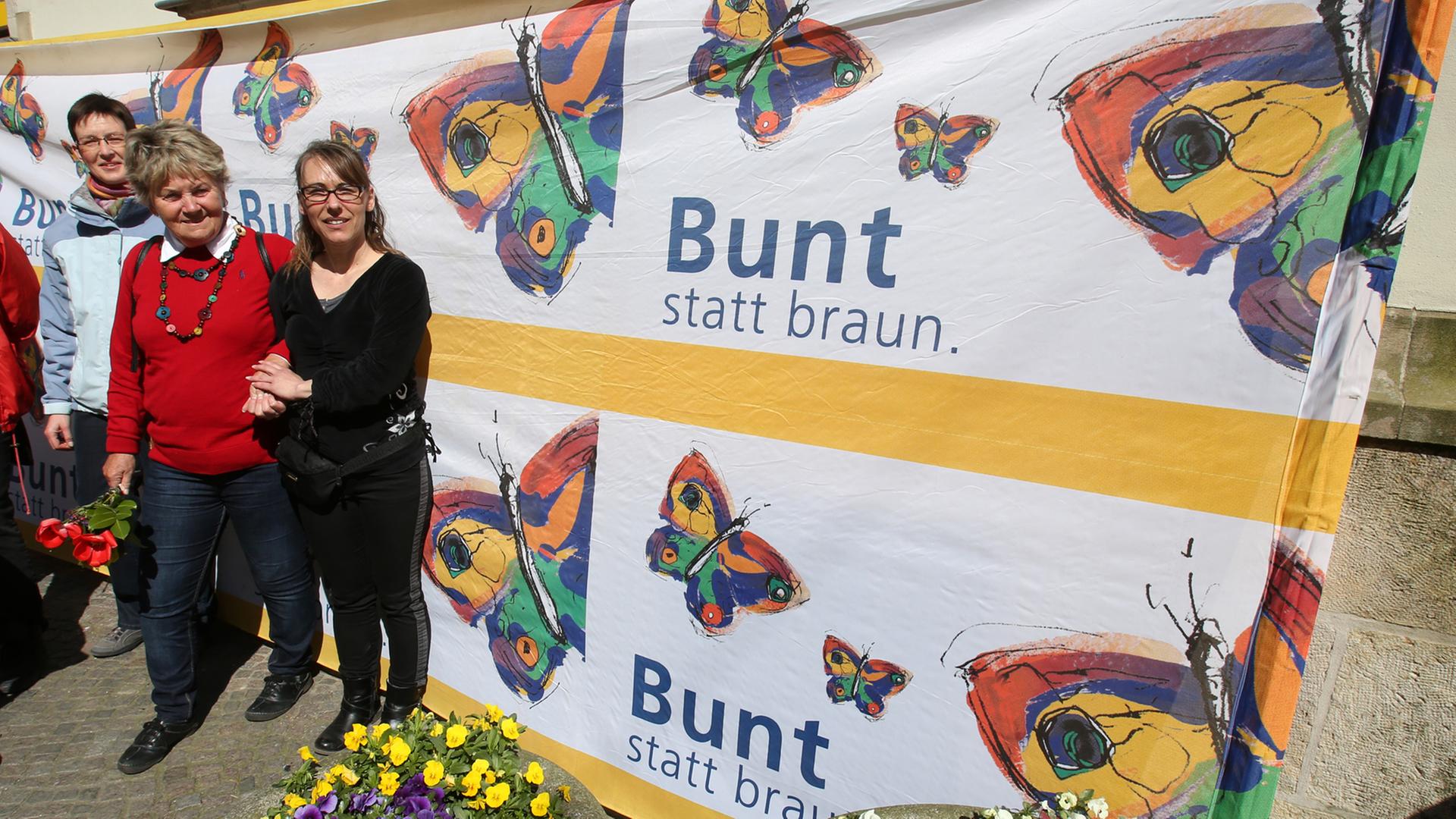 Vor der Villa Kunterbündnis in Güstrow (Mecklenbug-Vorpommern) steht am 19.04.2015 Geschäftsführerin Karen Larisch (r, Die Linke), um gemeinsam mit anderen gegen einen Aufmarsch der MVgida zu protestieren, auf dem Banner steht "Bunt statt braun". Vor der Villa Kunterbündnis in Güstrow (Mecklenbug-Vorpommern) steht am 19.04.2015 Geschäftsführerin Karen Larisch (r, Die Linke), um gemeinsam mit anderen gegen einen Aufmarsch der MVgida zu protestieren, auf dem Banner steht "Bunt statt braun".