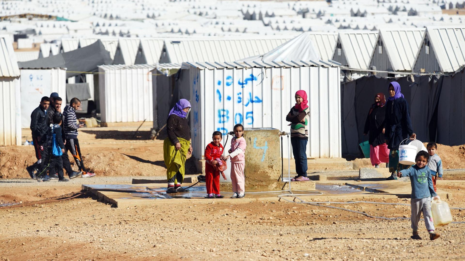 Syrer stehen am 08.12.2015 im Lager für syrische Flüchtlinge des Flüchtlingswerks der Vereinten Nationen (UNHCR) in Azraq (Jordanien) an einer Wasserstelle. (UNHCR) geführt und liegt rund 100 Kilometer östlich der Hauptstadt Amman in der Wüste. Derzeit leben dort nach UN-Angaben rund 28 300 Menschen. Syrer stehen am 08.12.2015 im Lager für syrische Flüchtlinge des Flüchtlingswerks der Vereinten Nationen (UNHCR) in Azraq (Jordanien) an einer Wasserstelle. (UNHCR) geführt und liegt rund 100 Kilometer östlich der Hauptstadt Amman in der Wüste. Derzeit leben dort nach UN-Angaben rund 28 300 Menschen.