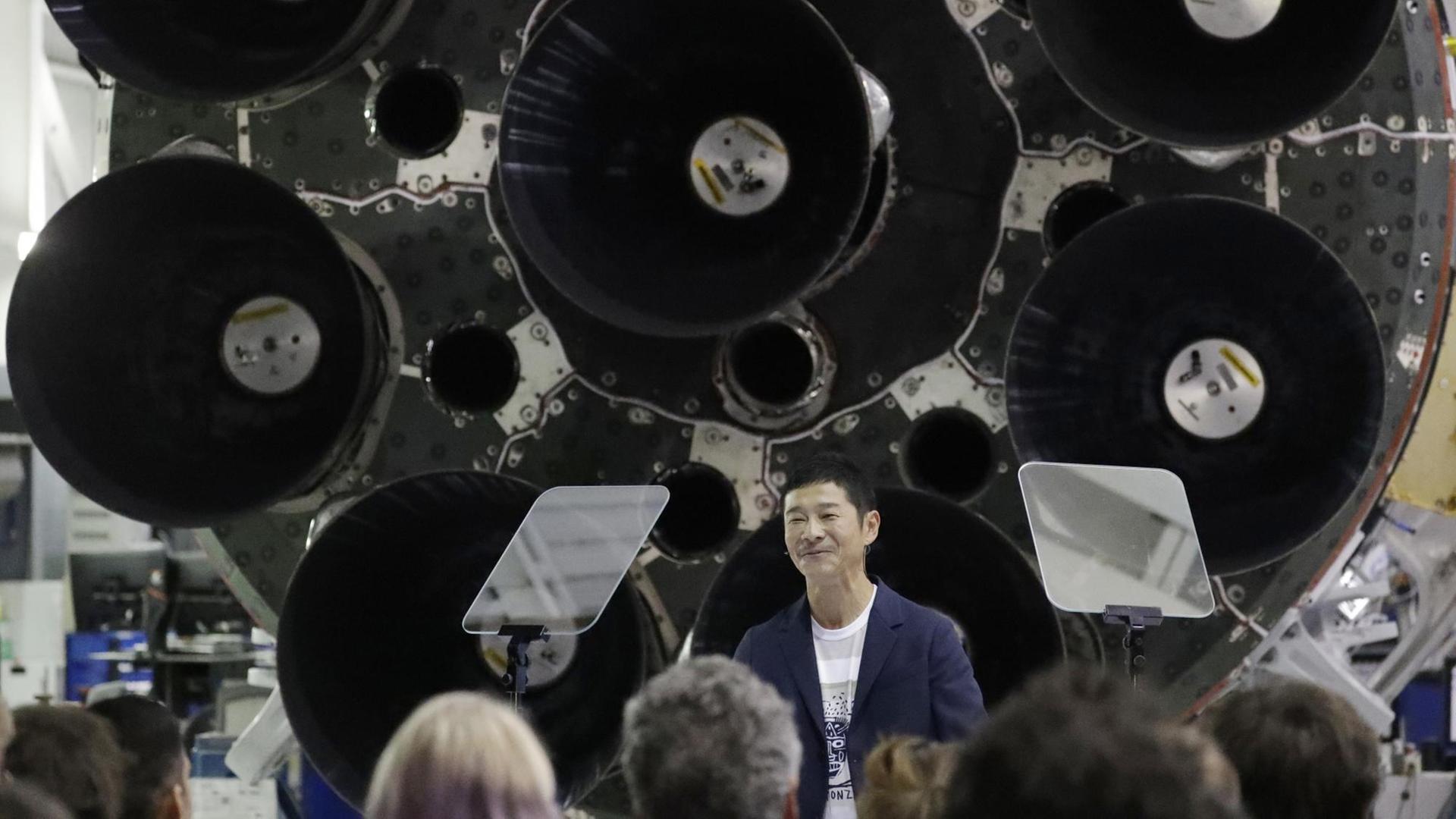 Der japanische Milliardär Yusaku Maezawa steht bei seiner Präsentation als erste Privatperson, die zum Mond reist, vor dem Unterteil einer Rakete.