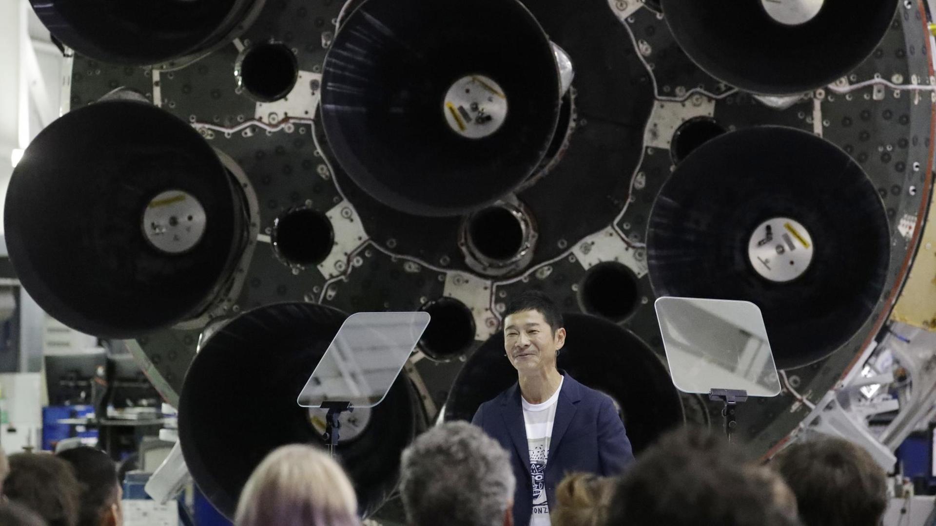 Der japanische Milliardär Yusaku Maezawa steht bei seiner Präsentation als erste Privatperson, die zum Mond reist, vor dem Unterteil einer Rakete. Der japanische Milliardär Yusaku Maezawa steht bei seiner Präsentation als erste Privatperson, die zum Mond reist, vor dem Unterteil einer Rakete.