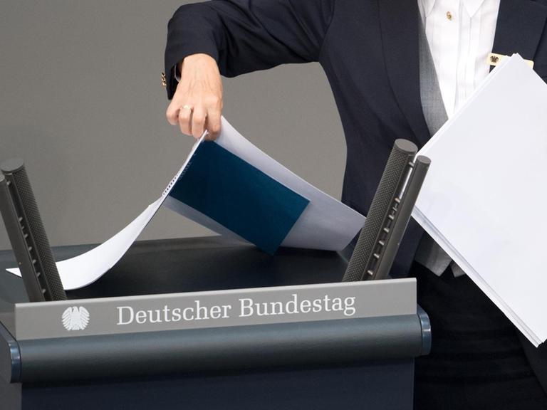 17.05.2018, Berlin: Akten werden vor der Plenarsitzung des Deutschen Bundestages im Reichstagsgebäude durch eine Saaldienerin vom Rednerpult genommemn. Hauptthemen der 33. Sitzung der 19. Legislaturperiode sind der Bundeshaushalt 2018, die Finanzplanung des Bundes für die Jahre 2017 bis 2021 sowie einzelne Ressort-Etats.