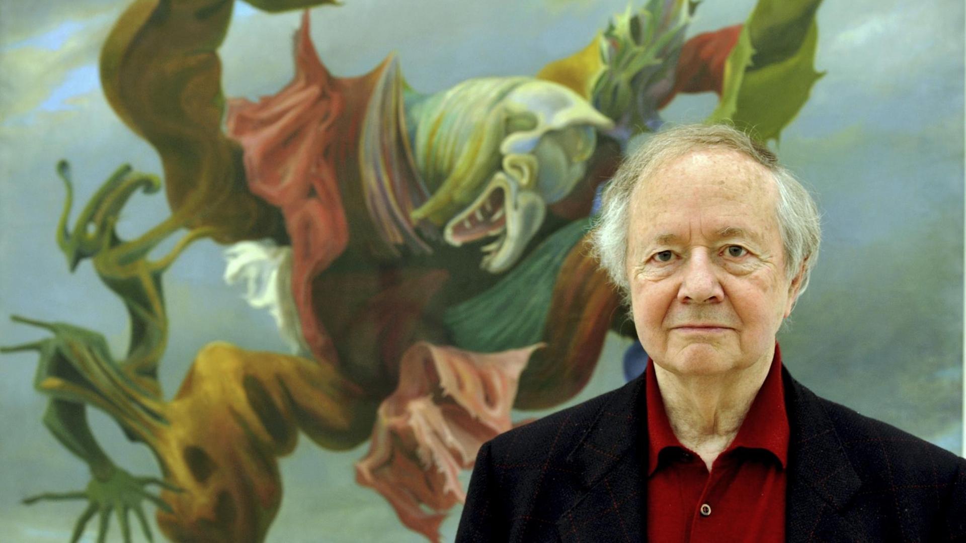 Werner Spies steht vor einem Bild auf dem eine wilde einem Drachen ähnliche Figur zu sehen ist. Werner Spies steht vor einem Bild auf dem eine wilde einem Drachen ähnliche Figur zu sehen ist.