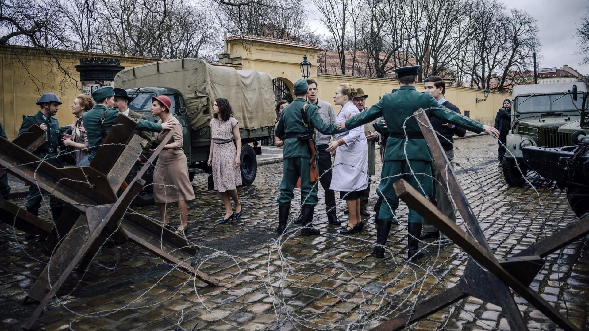 Vor der Charité wird eine Mauer errichtet - Soldaten halten Passanten zurück. Vor der Charité wird eine Mauer errichtet - Soldaten halten Passanten zurück.