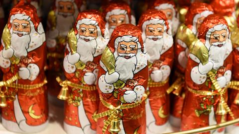 Weihnachtsmänner aus Schokolade stehen in einem Kaufhaus.