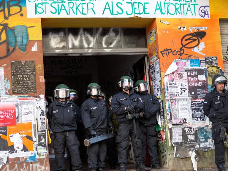 Polizisten durchsuchen ein linksalternatives Wohnprojekt in Berlin-Friedrichshain