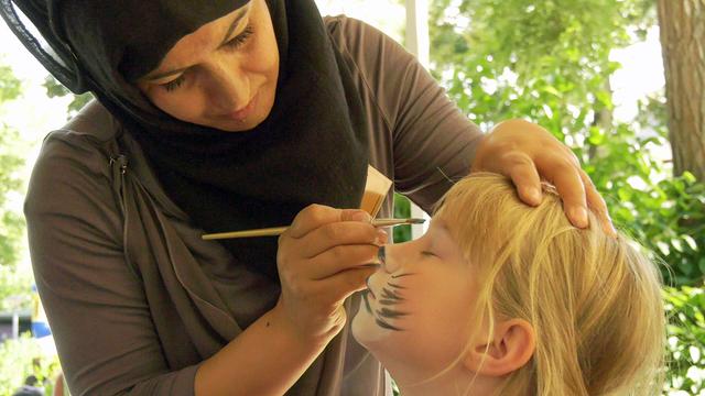 Kinderschminken im "Grand Beauty on Tour" mit einer geflüchteten Frau aus Afghanistan in Aue