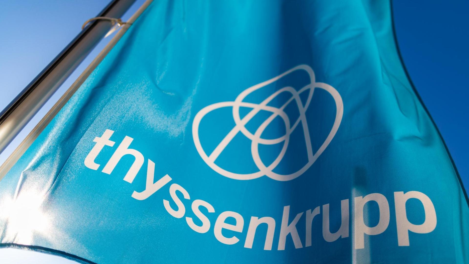 Eine Fahne mit dem Firmenlogo von Thyssenkrupp weht im Wind. Eine Fahne mit dem Firmenlogo von Thyssenkrupp weht im Wind.