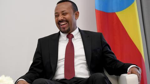 Abiy Ahmed, Premierminister von Äthiopien, sitzt auf einem Sofa und lächelt.