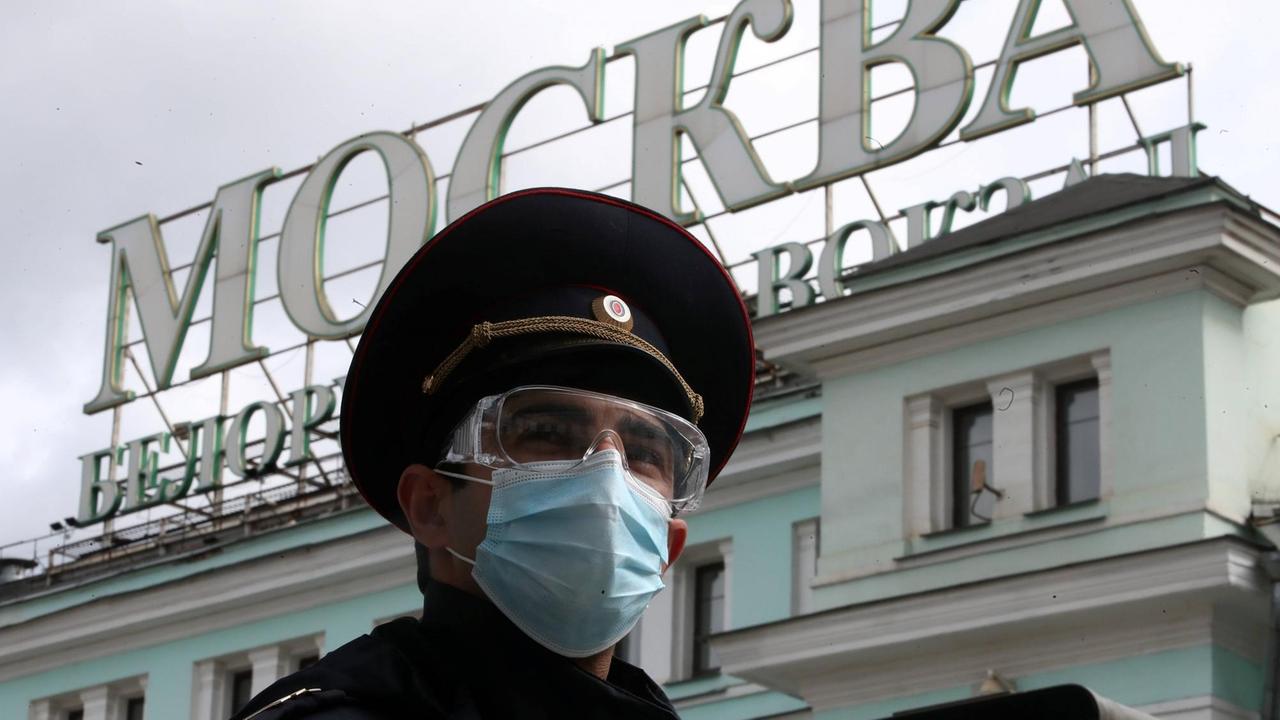 Ein Polizist mit Atemschutzmaske vor dem Bahnhof Belorussky in Moskau. Ein Polizist mit Atemschutzmaske vor dem Bahnhof Belorussky in Moskau.