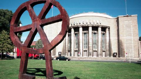 Die Berliner Volksbühne mit Rad-Skulptur