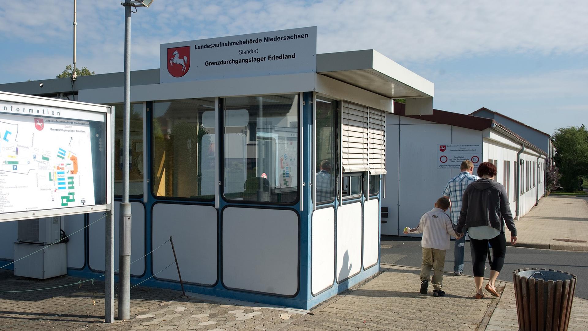 Eine Familie geht am 27.08.2013 im Grenzdurchgangslager Friedland (Niedersachsen) am Pförtner-Haus vorbei. Eine Familie geht am 27.08.2013 im Grenzdurchgangslager Friedland (Niedersachsen) am Pförtner-Haus vorbei.