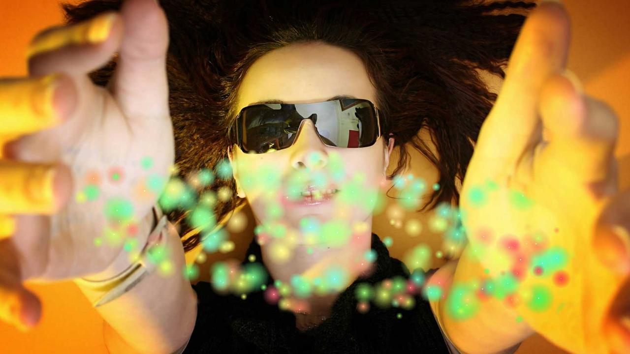 Junge Frau mit Sonnenbrille sieht bunte Punkte. Junge Frau mit Sonnenbrille sieht bunte Punkte.