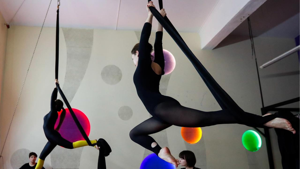 Junge Frauen nehmen an einem Aerial Silk Training an der Moskauer ArtArea Project School of Aerial Gymnastics teil. Junge Frauen nehmen an einem Aerial Silk Training an der Moskauer ArtArea Project School of Aerial Gymnastics teil.