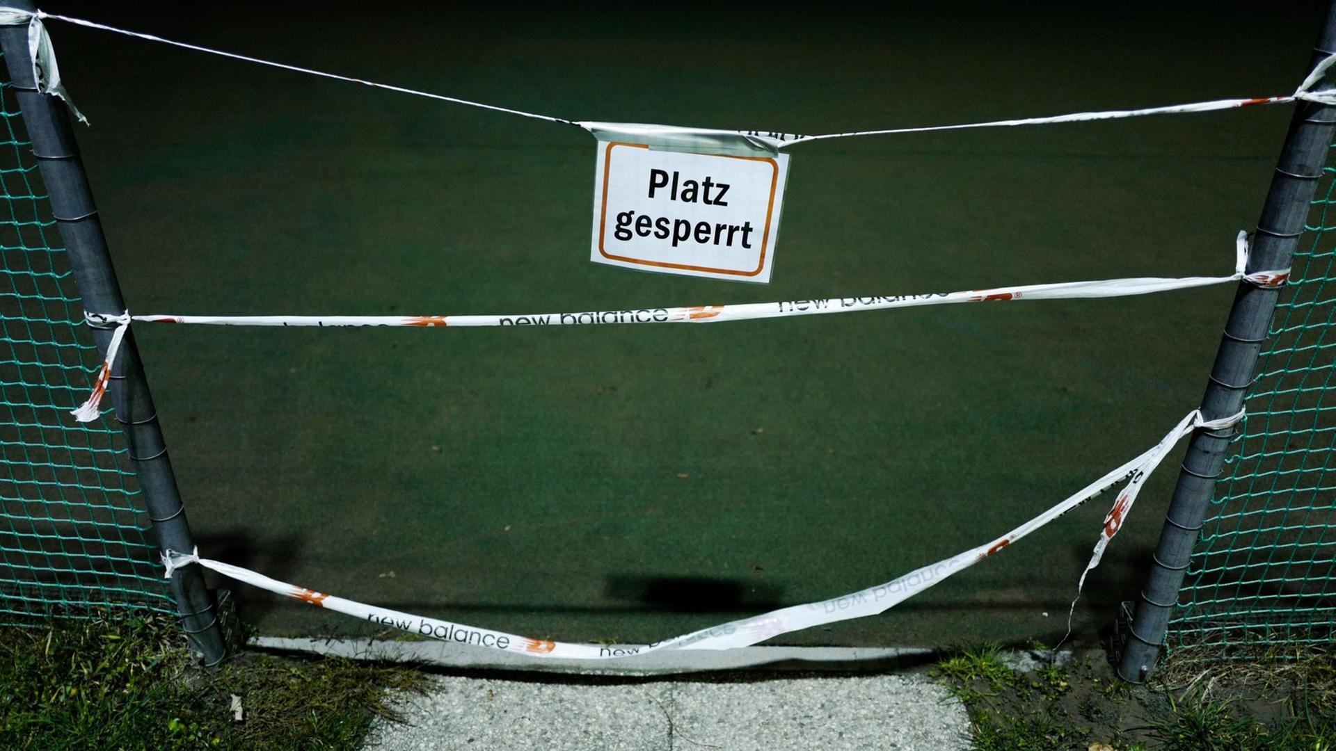 Ein Schild mit der Aufschrift "Platz gesperrt" hängt vor dem Eingang zu einem Tennisplatz. Ein Schild mit der Aufschrift "Platz gesperrt" hängt vor dem Eingang zu einem Tennisplatz.