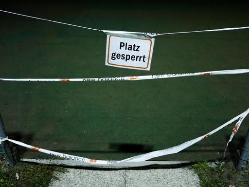 Ein Schild mit der Aufschrift "Platz gesperrt" hängt vor dem Eingang zu einem Tennisplatz.