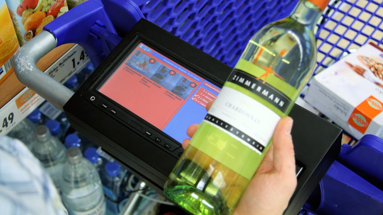 Ein Mann, der mit einem intelligenten Einkaufswagen an einem Regal steht, hält eine Flasche Wein. Der Einkaufswagen wurde vom Forschungszentrum für Künstliche Intelligenz (DFKI) in Saarbrücken entwickelt. Ein Mann, der mit einem intelligenten Einkaufswagen an einem Regal steht, hält eine Flasche Wein. Der Einkaufswagen wurde vom Forschungszentrum für Künstliche Intelligenz (DFKI) in Saarbrücken entwickelt.