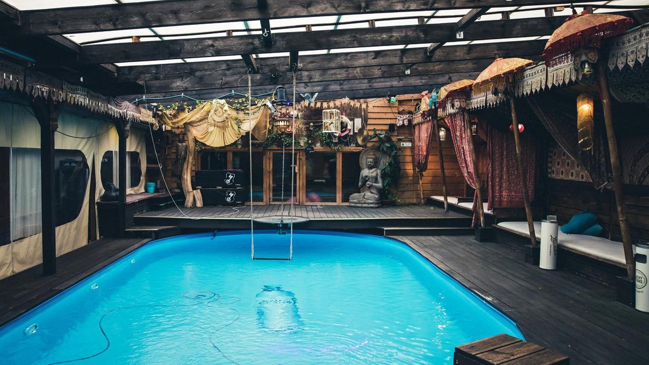 Foto aus dem Band "Hush – Berliner Clubkultur in Zeiten der Stille": Der während der Coronapandemie leere Berliner KitKat-Club mit einem Swimmingpool und einer Schaukel darüber. Foto aus dem Band "Hush – Berliner Clubkultur in Zeiten der Stille": Der während der Coronapandemie leere Berliner KitKat-Club mit einem Swimmingpool und einer Schaukel darüber.