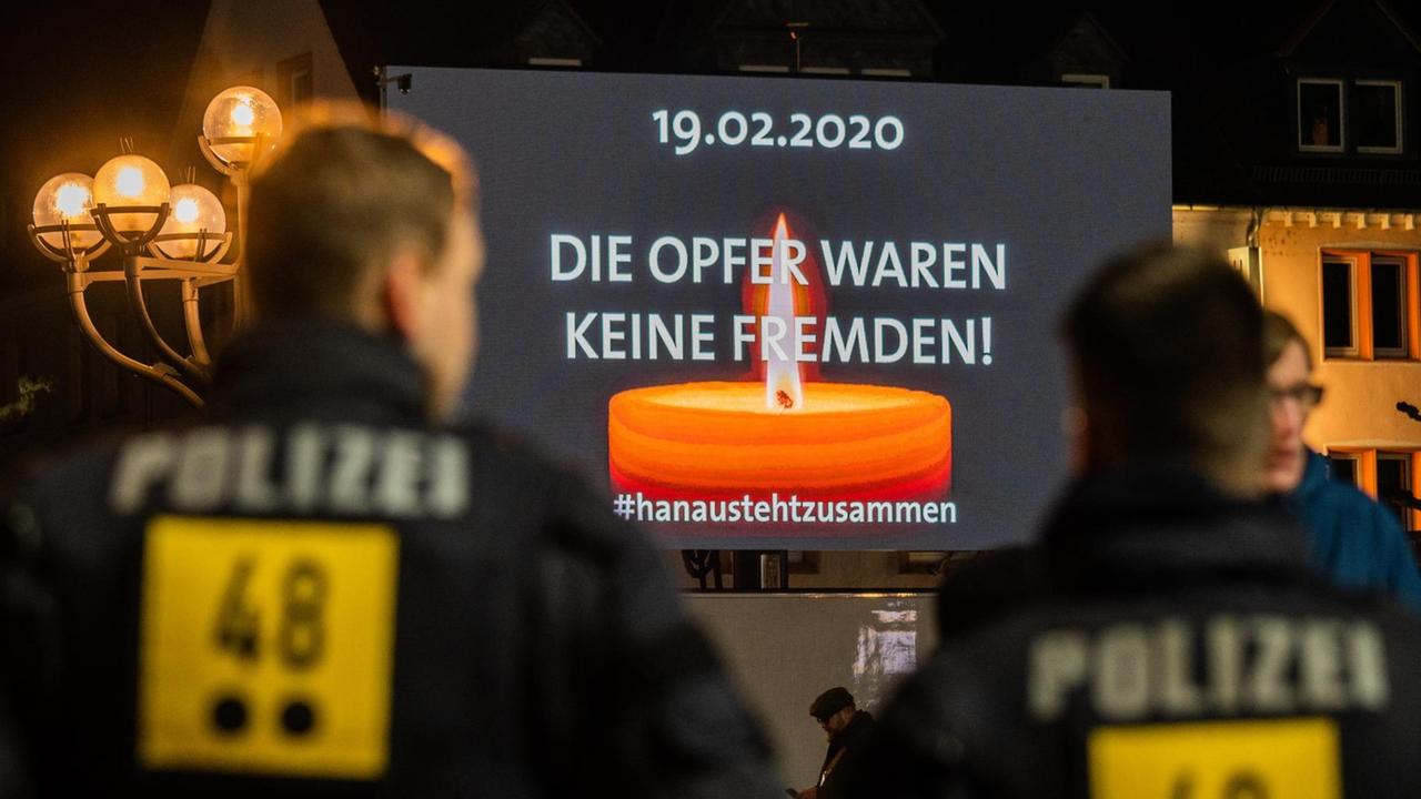 Polizisten stehen auf dem Hanauer Marktplatz, wo auf einer Videoleinwand die Trauerfeier für die Opfer der rassistischen Morde übertragen wird. Polizisten stehen auf dem Hanauer Marktplatz, wo auf einer Videoleinwand die Trauerfeier für die Opfer der rassistischen Morde übertragen wird.