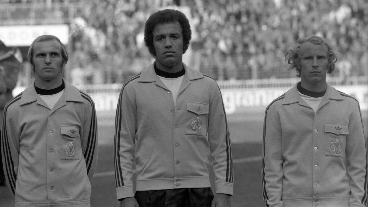 Beim singen der Nationalhymne: Deutschland, v.li.: Erich Beer, Erwin Kostedde und Berti Vogts, 1975. Beim singen der Nationalhymne: Deutschland, v.li.: Erich Beer, Erwin Kostedde und Berti Vogts, 1975.
