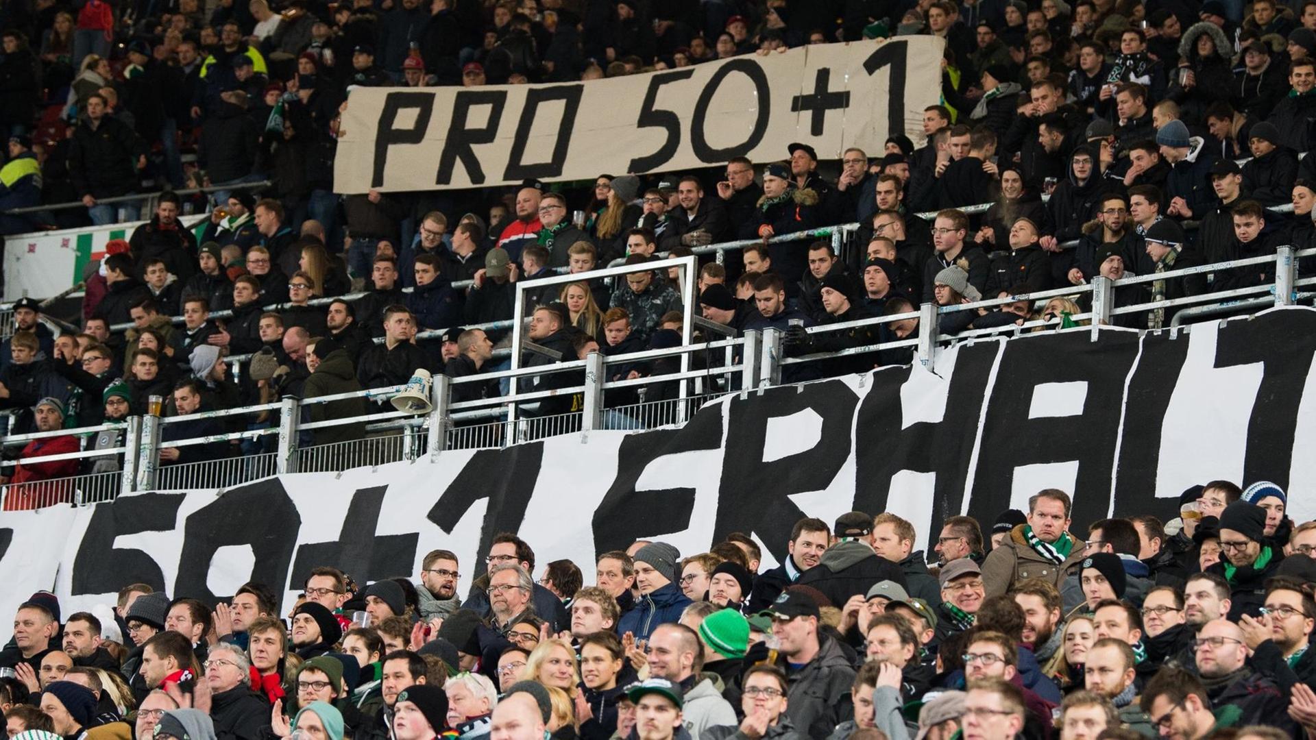 Fans von Hannover zeigen Plakate mit der Aufschrift "Pro 50+1". Fans von Hannover zeigen Plakate mit der Aufschrift "Pro 50+1".