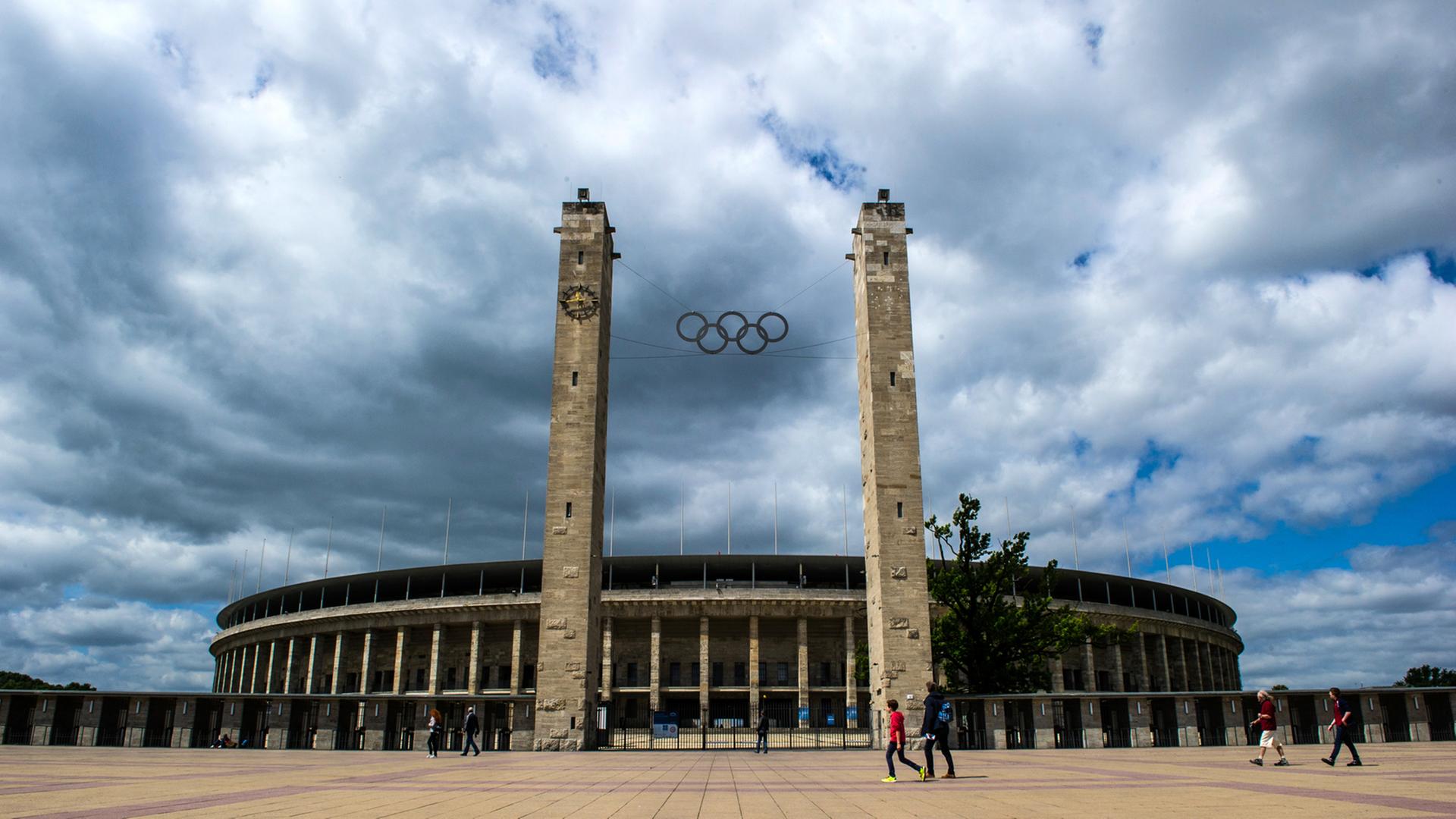 Menschen gehen am 23.06.2014 in Berlin am Olympiastadion vorbei. Menschen gehen am 23.06.2014 in Berlin am Olympiastadion vorbei.